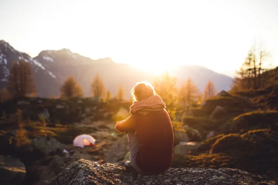 Frau entspannt ohne Smartphone in der Natur – Digital Detox für mehr Ruhe im Alltag