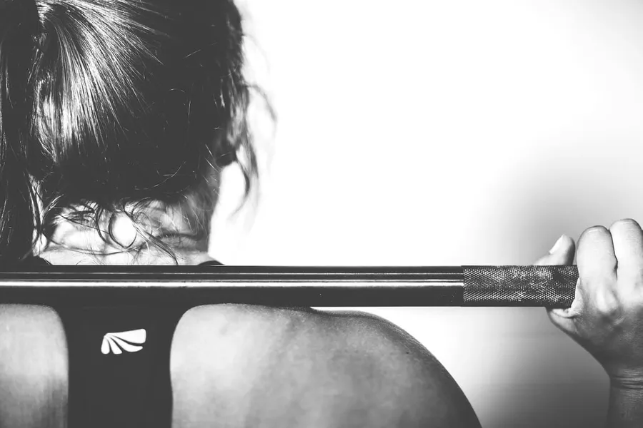 Erschöpfter Sportler sitzt nach dem Training auf dem Boden – Burnout durch Übertraining