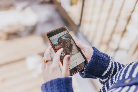 Frau schaut gestresst auf ihr Smartphone – Fear of missing out (FOMO) durch Social Media