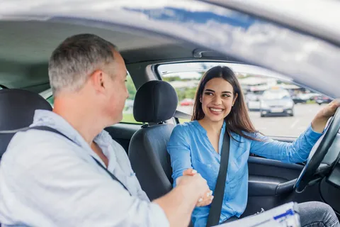 Junger Fahrschüler sitzt nervös am Steuer eines Autos vor seiner Führerscheinprüfung