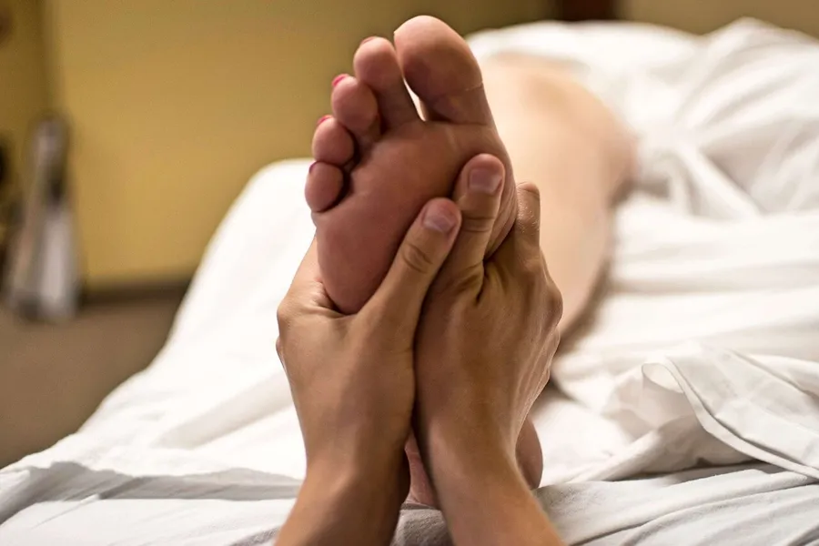 Fußreflexzonenmassage: Therapeutin massiert Fußsohle zur Stressreduktion und Entspannung