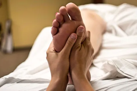 Fußreflexzonenmassage: Therapeutin massiert Fußsohle zur Stressreduktion und Entspannung