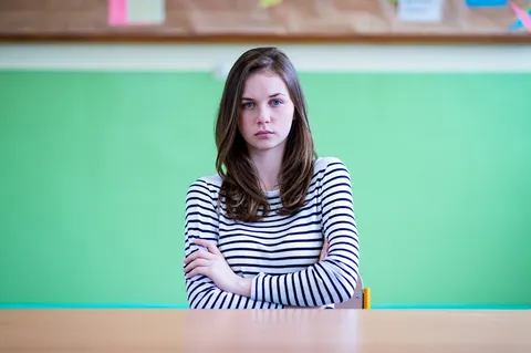 Kind sitzt allein auf dem Schulhof – Mobbing in der Schule erkennen und verhindern
