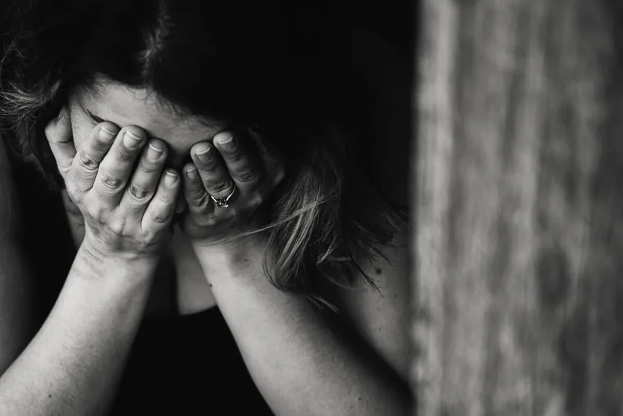 Erschöpfte Frau hält sich den Kopf – psychischer Stress und seine Folgen für Körper und Geist