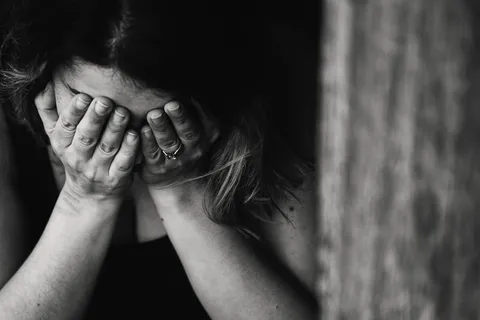 Erschöpfte Frau hält sich den Kopf – psychischer Stress und seine Folgen für Körper und Geist