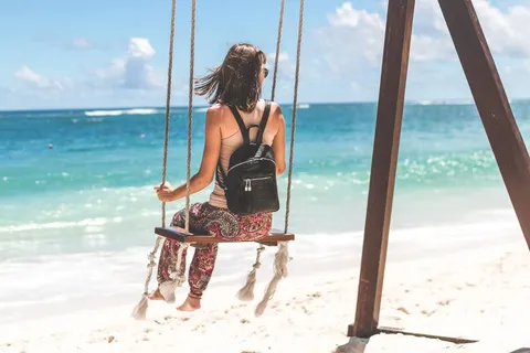 Person mit Rucksack genießt Auszeit in der Natur – Sabbatical als Pause vom Joballtag