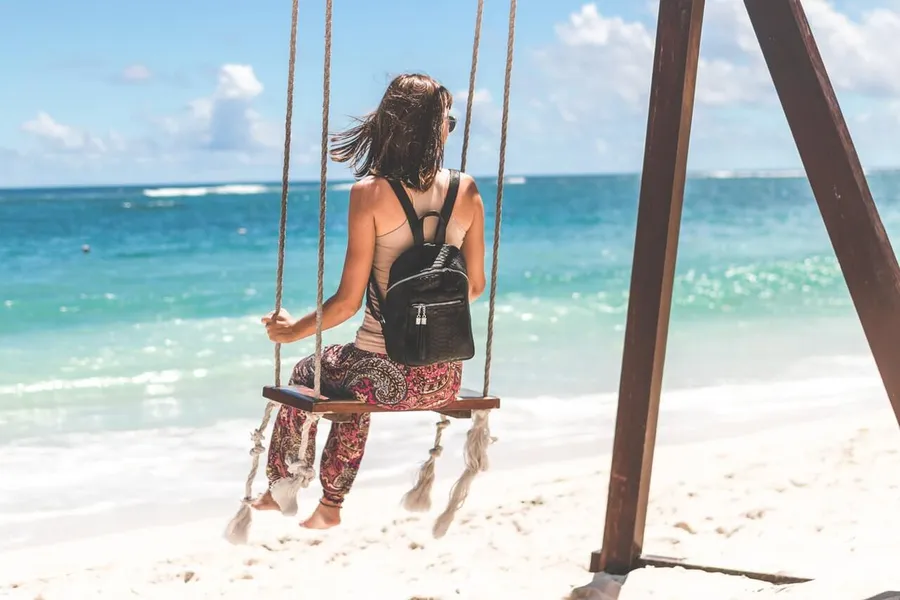 Person mit Rucksack genießt Auszeit in der Natur – Sabbatical als Pause vom Joballtag