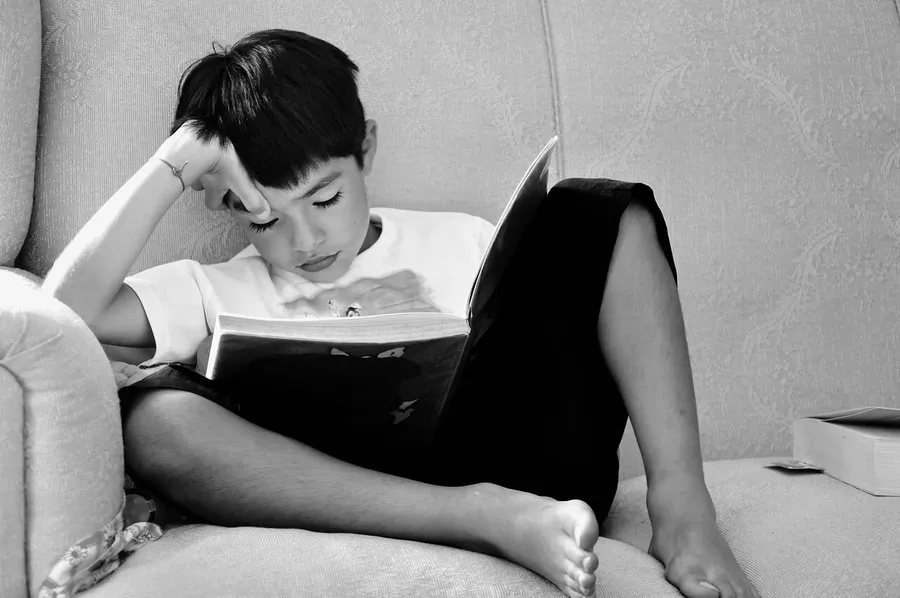Hochbegabtes Kind sitzt nachdenklich am Schreibtisch – Schulstress durch Unterforderung