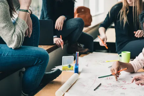 Kind sitzt gestresst am Schreibtisch mit Schulbüchern und Heften – Schulstress und seine Folgen