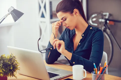 Gestresste Person reibt sich die Augen – Sehstörungen durch Stress als psychosomatisches Symptom