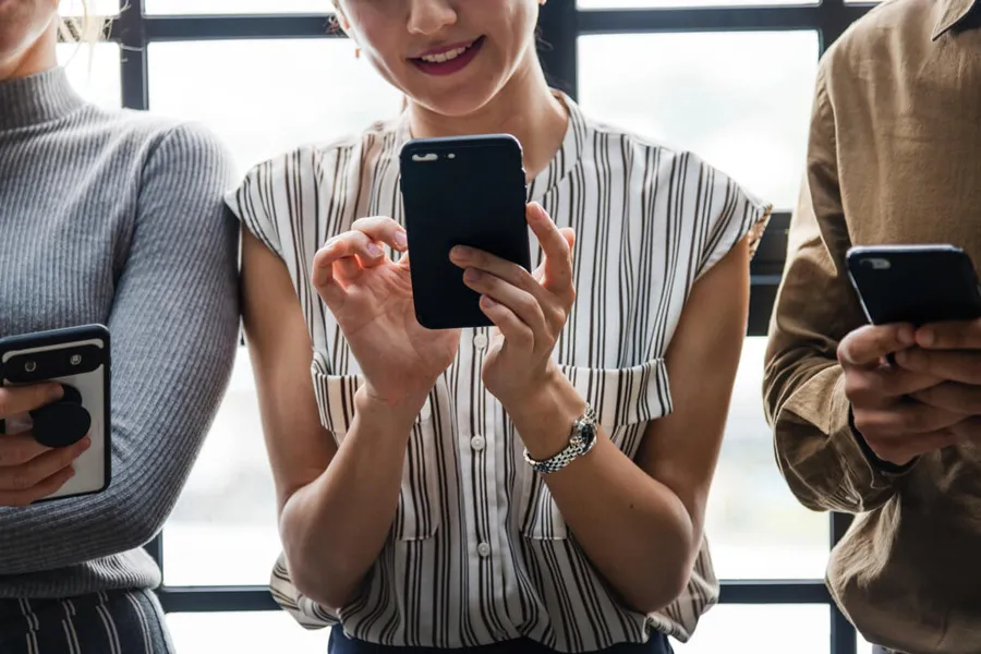 Jugendlicher schaut gestresst auf sein Smartphone – Social Media Stress und Suchtgefahr
