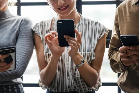 Jugendlicher schaut gestresst auf sein Smartphone – Social Media Stress und Suchtgefahr