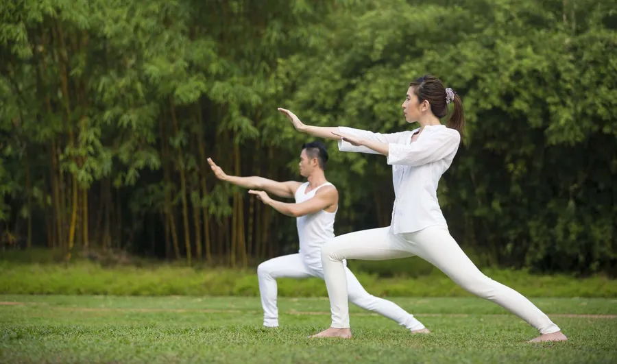 Person übt Tai Chi im Freien zur Stressreduktion und Entspannung