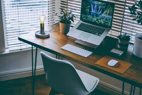 Person arbeitet entspannt im Home-Office am Schreibtisch und reduziert Stress durch Heimarbeit